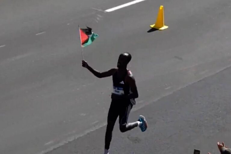 นักวิ่งมาราธอนของสหรัฐฯ โบกธงปาเลสไตน์ในการแข่งขันกีฬาโอลิมปิก
